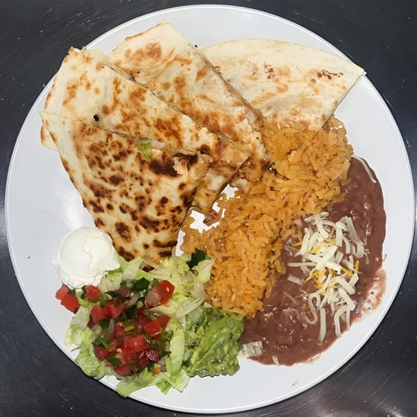 A white plate holds a quesadilla, rice, refried beans with cheese, guacamole, pico de gallo, and sour cream.